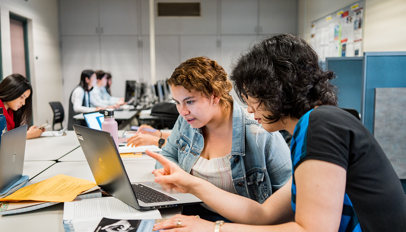 SBCC tutor helping a student on a computer.